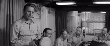 Movie still from “In Harm's Way” (1965), directed by Otto Preminger – A black and white photo of a group of men; Medium shot, Over the shoulder angle
