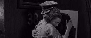 Movie still from “In Harm's Way” (1965), directed by Otto Preminger – A woman hugging a man wearing a uniform; Medium shot, Low angle