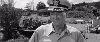 Movie still from “In Harm's Way” (1965), directed by Otto Preminger – An old photo of a man wearing a hat; Medium shot, Low angle