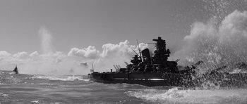 Movie still from “In Harm's Way” (1965), directed by Otto Preminger – A black and white photo of a battleship in the water; Extreme Wide shot, Low angle