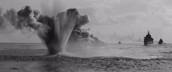 Movie still from “In Harm's Way” (1965), directed by Otto Preminger – A helicopter flying over a body of water with smoke billowing from it; Extreme Wide shot, High angle