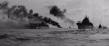 Movie still from “In Harm's Way” (1965), directed by Otto Preminger – Smoke billows out of a boat in the ocean; Extreme Wide shot, Low angle