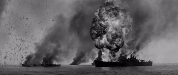 Movie still from “In Harm's Way” (1965), directed by Otto Preminger – Two ships in the water with a large explosion in the background; Extreme Wide shot, High angle