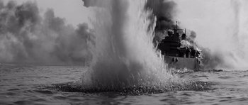 Movie still from “In Harm's Way” (1965), directed by Otto Preminger – A black - and - white photo of a ship in the water; Extreme Wide shot, Low angle
