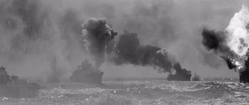 Movie still from “In Harm's Way” (1965), directed by Otto Preminger – A black - and - white photo of smoke billowing out of a ship; Extreme Wide shot, High angle