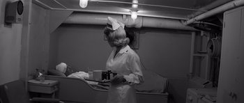 Movie still from “In Harm's Way” (1965), directed by Otto Preminger – A woman in a nurse's uniform holding a tray of food; Medium shot, High angle