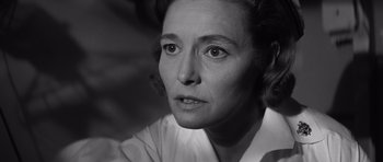 Movie still from “In Harm's Way” (1965), directed by Otto Preminger – An old photo of an older woman looking at the camera; Close Up shot, Low angle