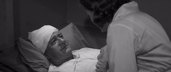 Movie still from “In Harm's Way” (1965), directed by Otto Preminger – An older man in a hospital bed talking to a nurse; Close Up shot, High angle