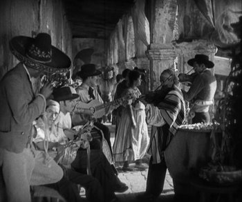 Movie still from “In Old Arizona” (1928), directed by Raoul Walsh – A black and white photo of a group of people; Wide shot, High angle