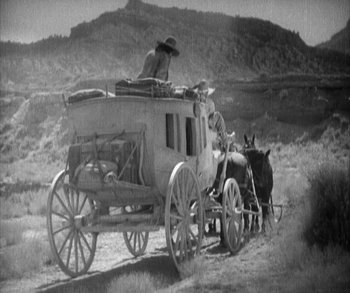Movie still from “In Old Arizona” (1928), directed by Raoul Walsh – An old time stagecoach with two men on it and a horse; Wide shot, Low angle
