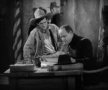 Movie still from “In Old Arizona” (1928), directed by Raoul Walsh – Two men sitting at a table in front of one another; Medium shot, High angle