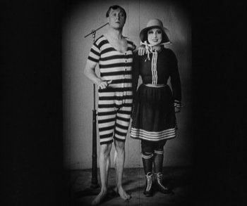 Movie still from “In Old Arizona” (1928), directed by Raoul Walsh – A man and a woman dressed in sailor outfits; Wide shot, Low angle