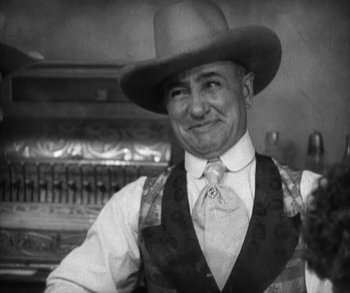 Movie still from “In Old Arizona” (1928), directed by Raoul Walsh – A man wearing a cowboy hat and a vest; Close Up shot, Low angle