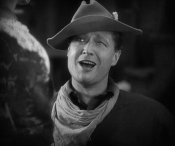 Movie still from “In Old Arizona” (1928), directed by Raoul Walsh – A man wearing a cowboy hat and a scarf; Close Up shot, Low angle