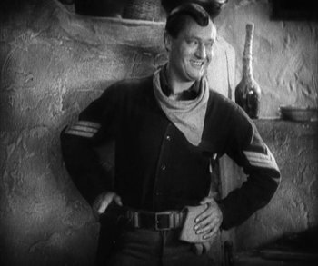 Movie still from “In Old Arizona” (1928), directed by Raoul Walsh – A man standing in front of a brick wall; Medium shot, Low angle