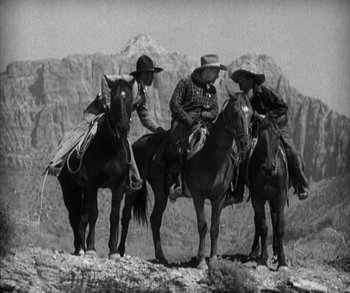 Movie still from “In Old Arizona” (1928), directed by Raoul Walsh – A group of men riding horses on top of a hill; Wide shot, Low angle
