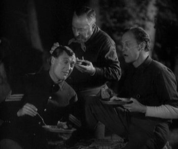 Movie still from “In Old Arizona” (1928), directed by Raoul Walsh – A group of people sitting around eating food; Medium shot, High angle