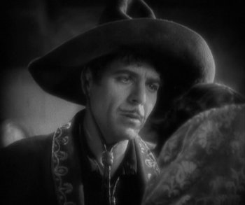 Movie still from “In Old Arizona” (1928), directed by Raoul Walsh – A black and white photo of a man wearing a cowboy hat; Close Up shot, Low angle