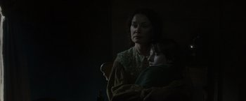 Movie still from “In Secret” (2013), directed by Charlie Stratton – A woman and a child in a dark room; Medium shot, Low angle