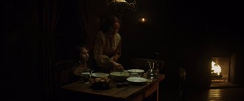 Movie still from “In Secret” (2013), directed by Charlie Stratton – A woman and a child sitting at a dinner table; Medium shot, High angle