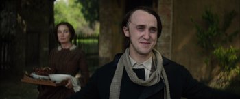 Movie still from “In Secret” (2013), directed by Charlie Stratton – A man with long black hair wearing a scarf; Close Up shot, Over the shoulder angle