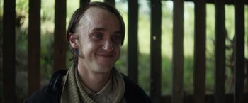 Movie still from “In Secret” (2013), directed by Charlie Stratton – A person with a beard smiling; Close Up shot, Low angle