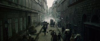 Movie still from “In Secret” (2013), directed by Charlie Stratton – An image of an old city street with people walking down the street; Extreme Wide shot, High angle