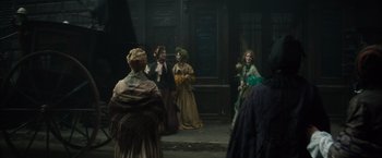 Movie still from “In Secret” (2013), directed by Charlie Stratton – A group of people dressed in period clothing; Wide shot, Over the shoulder angle