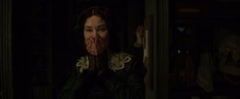 Movie still from “In Secret” (2013), directed by Charlie Stratton – A woman with her hands over her mouth; Close Up shot, Over the shoulder angle