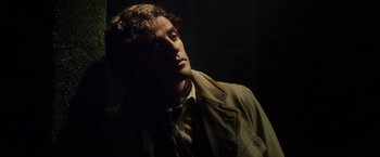 Movie still from “In Secret” (2013), directed by Charlie Stratton – A man in a brown jacket is looking to the side; Close Up shot, Over the shoulder angle