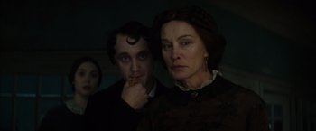 Movie still from “In Secret” (2013), directed by Charlie Stratton – A man and a woman standing next to each other in a dark room; Close Up shot, Over the shoulder angle