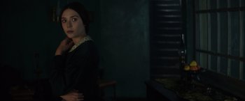 Movie still from “In Secret” (2013), directed by Charlie Stratton – A woman standing in a dark room with her hands on her hips; Medium shot, Over the shoulder angle