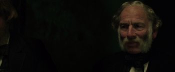 Movie still from “In Secret” (2013), directed by Charlie Stratton – An old man with a beard is looking at the camera; Close Up shot, Over the shoulder angle