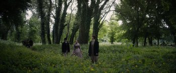 Movie still from “In Secret” (2013), directed by Charlie Stratton – A group of people standing in the middle of a forest; Wide shot, Over the shoulder angle