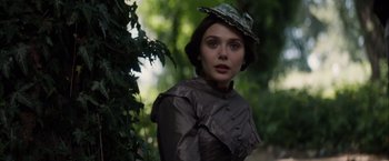 Movie still from “In Secret” (2013), directed by Charlie Stratton – A woman in a hat standing next to a tree; Close Up shot, Low angle