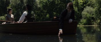 Movie still from “In Secret” (2013), directed by Charlie Stratton – A man and woman in a row boat on a river; Medium shot, High angle