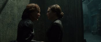 Movie still from “In Secret” (2013), directed by Charlie Stratton – Two women are facing each other in a dark room; Close Up shot, Over the shoulder angle