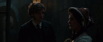 Movie still from “In Secret” (2013), directed by Charlie Stratton – A man and a woman are standing next to each other; Close Up shot, Over the shoulder angle