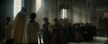 Movie still from “In Secret” (2013), directed by Charlie Stratton – A couple of people that are in a church; Wide shot, Over the shoulder angle