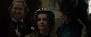 Movie still from “In Secret” (2013), directed by Charlie Stratton – A woman with a hat on and two other women standing next to her; Close Up shot, Over the shoulder angle