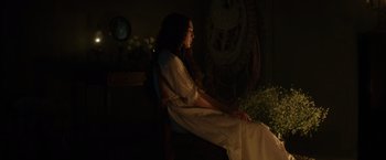 Movie still from “In Secret” (2013), directed by Charlie Stratton – A woman sitting on a chair in a dark room; Medium shot, High angle