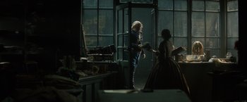 Movie still from “In Secret” (2013), directed by Charlie Stratton – A man and a woman standing in front of an open door; Wide shot, Over the shoulder angle