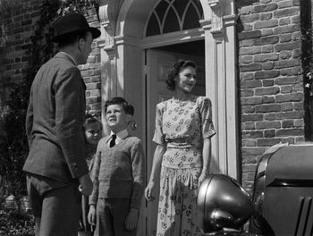 Movie still from “In Which We Serve” (1942), directed by Noël Coward – An old photo of a woman and two children outside a house; Medium shot, Low angle