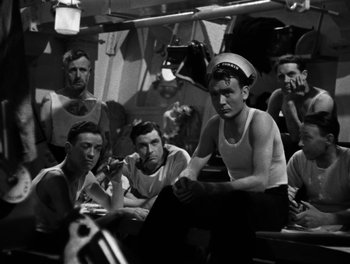 Movie still from “In Which We Serve” (1942), directed by Noël Coward – A black and white photo of a group of men sitting on a boat; Medium shot, High angle