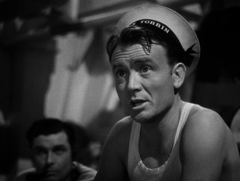 Movie still from “In Which We Serve” (1942), directed by Noël Coward – A man wearing a sailor's hat in a black and white photo; Close Up shot, Low angle