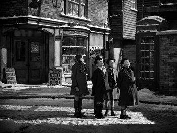 Movie still from “In Which We Serve” (1942), directed by Noël Coward – A group of people standing on the side of the street; Wide shot, Low angle