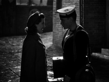 Movie still from “In Which We Serve” (1942), directed by Noël Coward – A man and a woman talking to each other; Medium shot, High angle