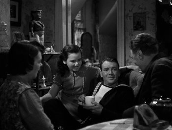 Movie still from “In Which We Serve” (1942), directed by Noël Coward – A group of people sitting around in a room together; Medium shot, High angle