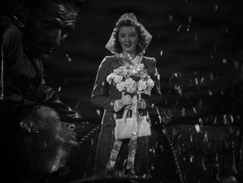 Movie still from “In Which We Serve” (1942), directed by Noël Coward – A woman holding a bouquet of flowers in her hands; Medium shot, High angle