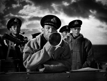 Movie still from “In Which We Serve” (1942), directed by Noël Coward – Black and white photograph of men in military uniforms; Medium shot, Low angle